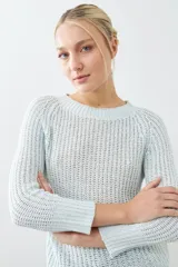 Sweater rojo de tejido de punto con ruedo curvo y mangas 3/4.