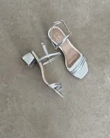 Sandalias doradas de fiesta con tiras finas y taco cuadrado bajo.