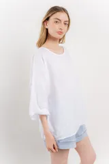 Blusa color beige confeccionada en lino, de corte holgado, mangas 3/4 y cuello redondo.
