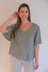 Blusa verde con escote en V y mangas cortas con volados.