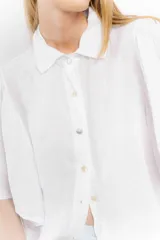 Camisa blanca de lino con cuello clásico y mangas cortas acampanadas.
