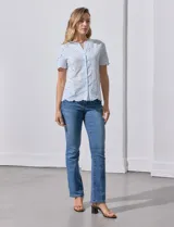 Blusa celeste de algodón con bordado broderie, cuello a la base con abertura central y botones.