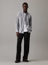 Camisa de vestir gris claro de corte regular, confeccionada en tejido Oxford de algodón y elastano, con cierre frontal abotonado, mangas largas y logo CK bordado en el pecho.