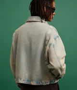 Campera overboxy de jean celeste con efecto lavado, cuello inglés, cierre frontal con cremallera, manga larga y bolsillo con cierre en el pecho. Confeccionada con algodón BCI más sostenible.
