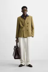 Blazer color marrón claro, de corte recto y doble botonadura. Confeccionado en tejido de lyocell y lino.