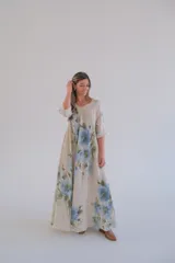 Vestido largo color beige con estampado de flores azules, corte amplio, escote en V y mangas 3/4.