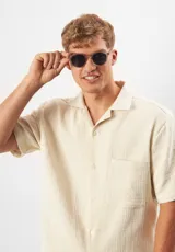 Lentes de sol Eco Shades Costa, con montura redonda color champagne y lentes grises. Fabricados con acetato biodegradable y lentes de PMMA reciclado.