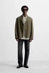 Blazer color verde oliva de algodón con efecto lavado, corte relaxed fit, cuello con solapas de muesca, manga larga y bolsillos frontales de plastrón. Cierre frontal con dos botones.