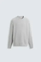 Jersey gris de algodón con cuello redondo, manga larga y terminaciones en rib.