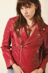 Campera de cuero ovino negra, estilo motociclista, con cierre asimétrico, cuello con broches a presión y detalles de matelaseado en hombros y cintura. Presenta cierres metálicos plateados en puños y bolsillos.