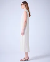 Vestido largo de tejido de punto color crudo, con textura metalizada, cuello escote en V y tajos laterales.