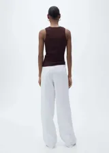Musculosa blanca de tejido de punto fino, cuello redondo, tirantes anchos y diseño entallado.