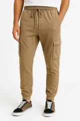 Pantalón babucha color beige con cintura elástica ajustable con cordón, bolsillos laterales y corte holgado.