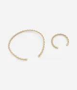 Conjunto de collar gargantilla y pulsera rígida con detalles torcidos, color dorado.