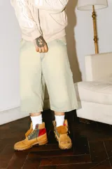 Bermuda de jean verde claro con efecto lavado, corte baggy, estilo carpintero con bolsillo lateral y tira lateral.