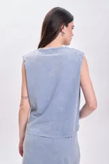 Camiseta celeste con cuello redondo y sisas anchas con hombreras marcadas.
