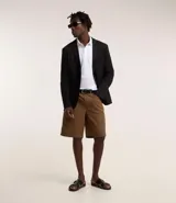 Polo blanca de corte regular, con cuello inglés, tapeta con botones y detalles texturizados.