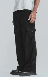 Pantalón negro de pana con corte ancho, cintura elástica y bolsillos cargo.