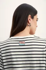 Remera de manga corta con cuello redondo y estampado de rayas horizontales blancas y negras. Mangas abullonadas con puño blanco.