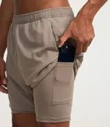 Bermuda deportiva color bordó, confeccionada en poliéster, con cintura elástica, cordón interno ajustable y short de compresión incorporado.