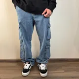 Pantalón jean cargo negro con corte holgado y múltiples bolsillos.