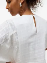 Vestido largo blanco de algodón con encaje, botones frontales, forro interior y corte regular.