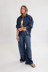 Camisa de denim azul con bordados y parche con logo en el frente.