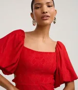 Vestido corto blanco de laise con bordado de flores, escote cuadrado, mangas cortas abullonadas y corte evasé.