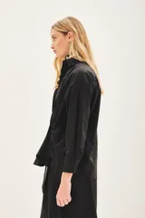 Camisa beige de poplin amplia, con botones laterales para abotonar de forma cruzada.