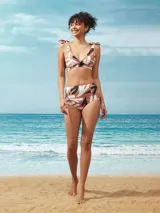 Top de bikini con estampado abstracto en tonos marrón, blanco y negro. Tiene corte triangular, breteles con lazos y copas removibles.