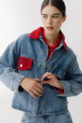 Campera de jean celeste con cuello y bolsillo con detalles de crochet blanco.