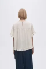 Blusa color coral con cuello redondo y mangas cortas con volados.