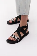 Sandalias negras con tiras cruzadas de cuero y pelo vacuno con estampado animal print.