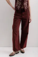 Pantalón de jean color bordó, corte baggy, tiro medio, con cuatro bolsillos y pinzas en las rodillas.