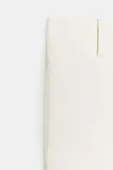 Pantalón culotte de tiro alto color crudo, con bolsillos delanteros y traseros. Cierre frontal con cremallera y ganchos metálicos.