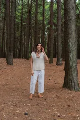 Chaleco color crudo tejido a mano en hilado 100% baby alpaca, con cuello tipo bote, hombros anchos, puntos calados en frente y espalda, y tajos laterales en el bajo.