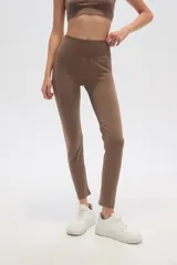 Calza larga color marrón topo, de poliamida, tiro alto y calce ajustado.