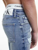 Jeans skinny de tiro bajo, color azul claro vintage con efecto desgastado y rotos en las piernas.