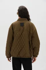 Campera matelaseada negra con diseño geométrico y escote en forma de V, con ajuste regulable en los puños.