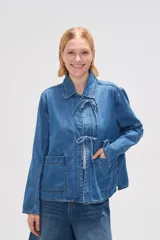 Chaqueta de jean azul con cuello camisero, cierre frontal con lazos y bolsillos de parche.