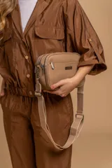 Bandolera color mostaza de simil cuero, con tres cierres principales, cierre delantero y bolsillo trasero. Incluye correa ajustable.