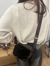 Bandolera de cuero marrón con panel frontal de piel sintética con estampado animal en tonos verde oliva y marrón. Tiene correa larga regulable, cierre superior con cremallera y forro interior.