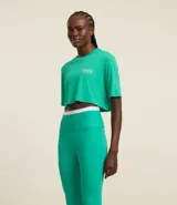 Remera deportiva cropped color verde con cuello redondo y mangas cortas amplias. Estampa con texto en el frente.