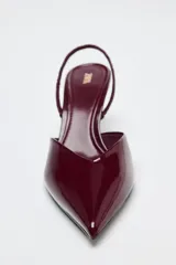 Zapato destalonado acharolado color borgoña, con escote en pico, cierre con tira trasera ajustable, tacón fino y punta fina.
