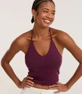 Top cropped de algodón color amarillo pálido, con escote en V pronunciado y tirantes finos que se atan en la nuca (estilo halter). El tejido es acanalado.