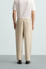 Pantalón verde militar de corte carrot fit, confeccionado en tejido de algodón. Cuenta con cintura elástica ajustable con cordón, bolsillos frontales y un bolsillo trasero de plastrón.