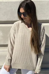Sweater negro de tejido de punto con escote en V y rayas verticales plateadas.