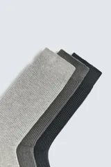 Pack de tres pares de calcetines de hombre tejidos en mezcla de algodón, con terminación acanalada. Incluye un par negro, un par gris oscuro y un par gris claro.