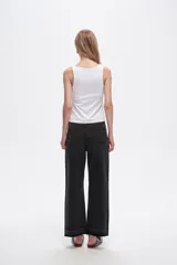 Pantalón jean negro de corte recto, tiro medio y ruedo desflecado.