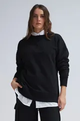 Sudadera negra de corte oversize, con cuello redondo y mangas largas.